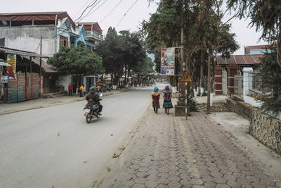 Rear view of woman riding bicycle on road