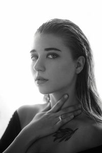 Close-up portrait of young woman over white background