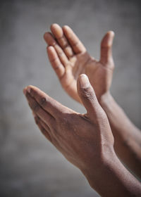 Close-up of hands gesturing against wall