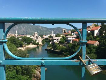 Close-up of bridge over cityscape against clear blue sky