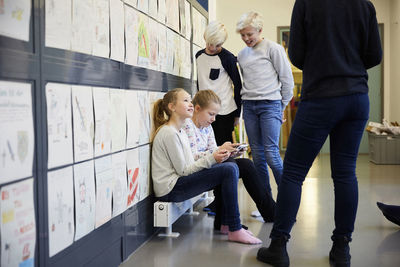 Teacher and children in middle school corridor