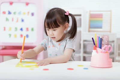 Young girl drawing different shape for home schooling 