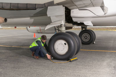 Male engineer removing brakes from plane wheel