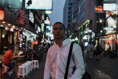 Full length of young man standing on street in city