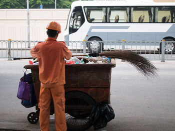 Rear view of man cycling on street