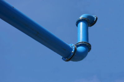 Low angle view of metal against blue sky