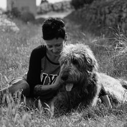 Young woman with dog sitting on grass