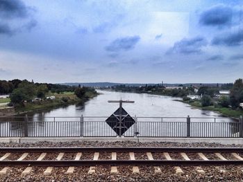 Railroad track against cloudy sky