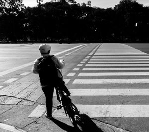 Full length of man riding bicycle on road