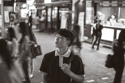 Man standing on footpath in city