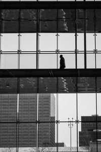 Silhouette person on glass window of building