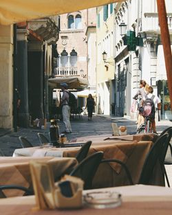 People walking on street by buildings in city