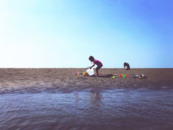 Girl playing with toys on sand at beach