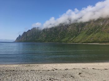 Scenic view of sea and mountains against sky