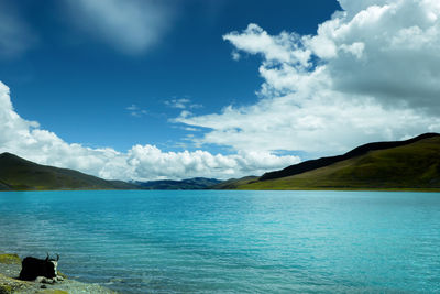 Scenic view of lake against cloudy sky