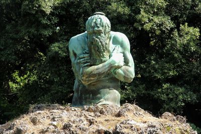 Statue against trees