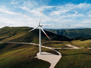 Wind turbines on mountain against sky