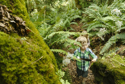 View from above of a young boy hiking through the trees with a feather