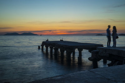 Silhouette people at beach during sunset