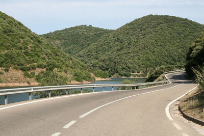 Road leading towards mountains against sky