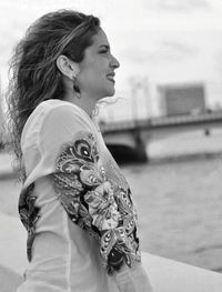 Side view of smiling woman standing by river