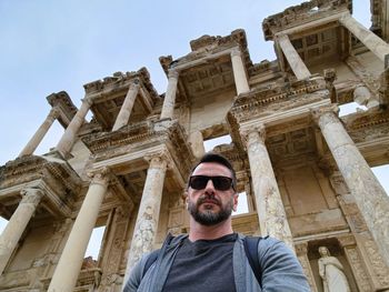 Portrait of man standing against historic building