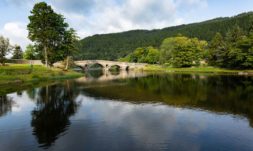 Arch bridge over lake against sky