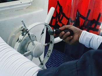 Cropped hand holding steering wheel in boat