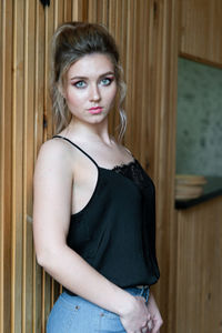 Portrait of beautiful young woman standing at home