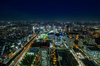 High angle view of illuminated buildings against sky at night