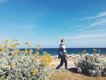 Full length of woman standing by sea against sky