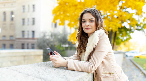 Beautiful woman using smart phone in city