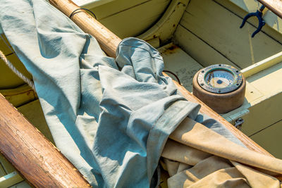 High angle view of canvas by compass in old boat