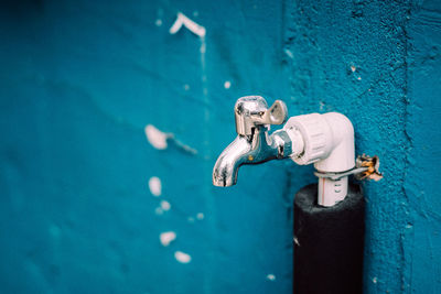 Close-up of tap on blue wall