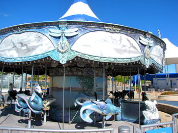 People at amusement park against clear blue sky