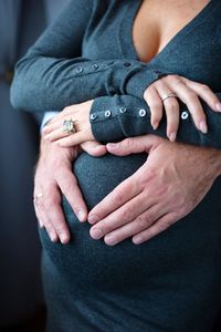 Cropped hands of man touching stomach of pregnant woman