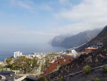 High angle view of town by sea against sky