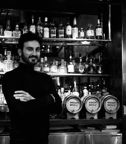 Portrait of man standing by bottles