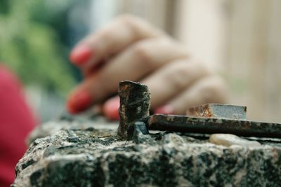 Close-up of metallic hammer with woman hand in background