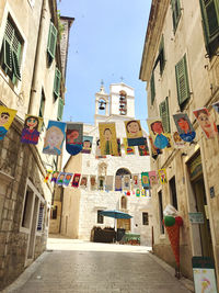 Alley amidst buildings against sky in city