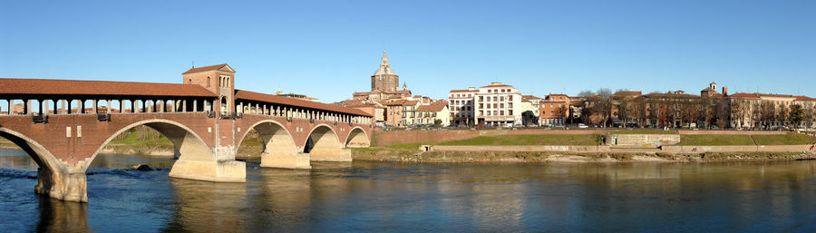 Arch bridge over river against buildings