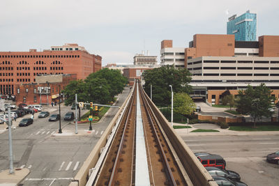 Railroad tracks in city against sky