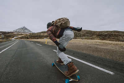 Rear view of man on road against sky