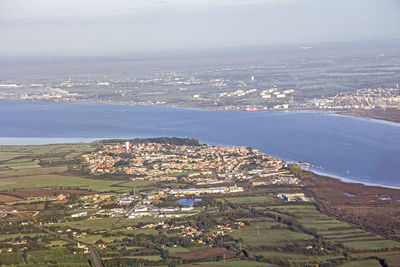 High angle view of cityscape and sea against sky