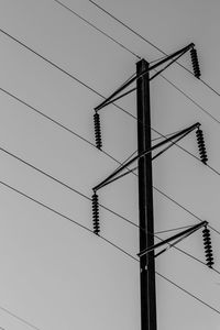 Low angle view of electricity pylon against clear sky