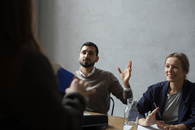 Male entrepreneur explaining female colleagues during meeting in office