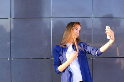 Portrait of woman standing against wall