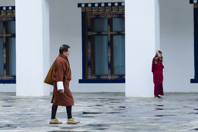 Rear view of woman standing against building