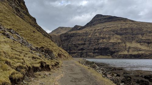 Scenic view of road by mountains against sky