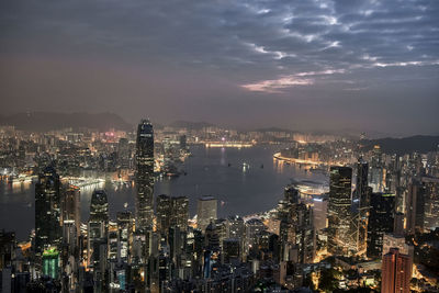 River amidst illuminated cityscape against sky at night